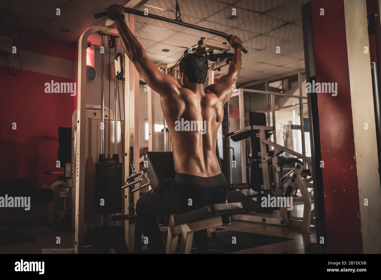 Un homme de fitness qui s'entraîner à la descente en lat à la salle de gym Banque D'Images