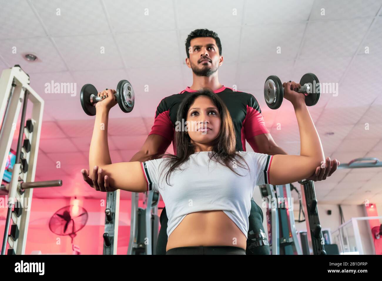 Personal trainer helping woman travail avec haltères Banque D'Images