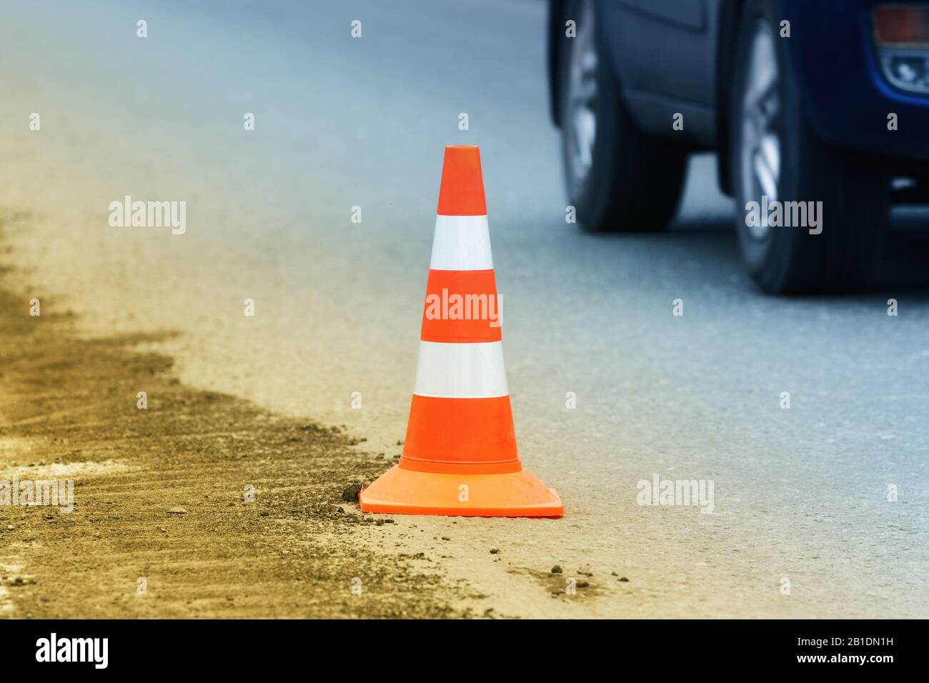 Avertissement cône de circulation debout sur la route de la ville d'asphalte de la rue pendant les travaux routiers, la réparation de routes, les travaux de chaussée d'asphalte sur la route Banque D'Images
