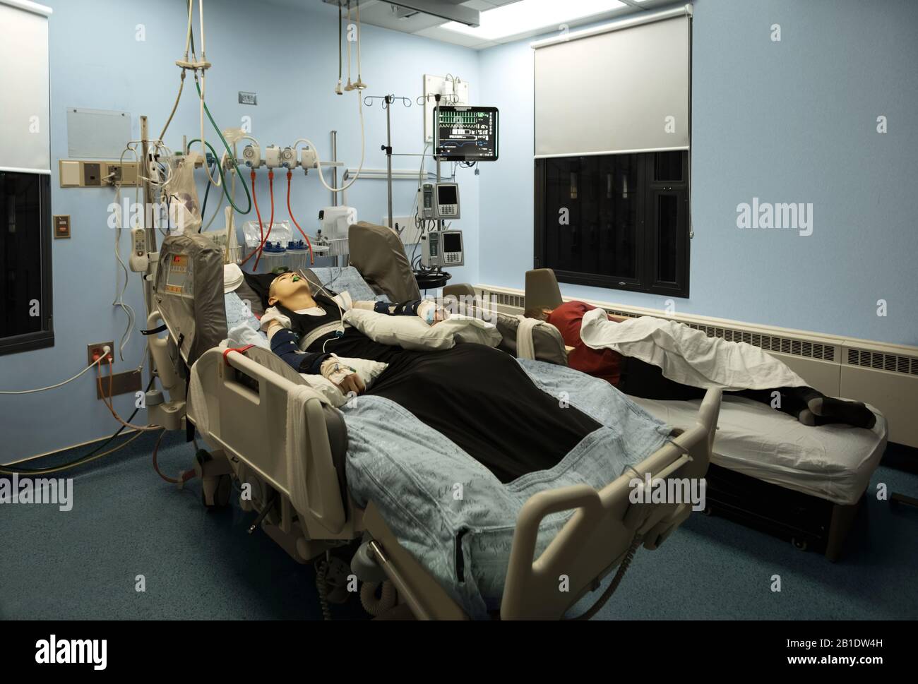 Père fatigué dormant à côté de l'inconscient handicapé fils dans le lit d'hôpital la nuit. L'enfant est muni d'un tube respiratoire. Banque D'Images