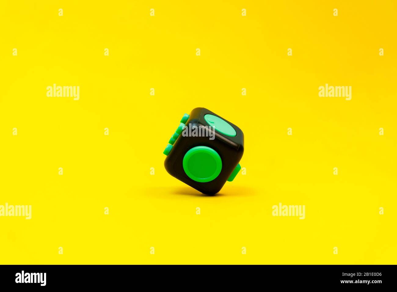 Gros plan de fidget noir et vert sur fond jaune Banque D'Images