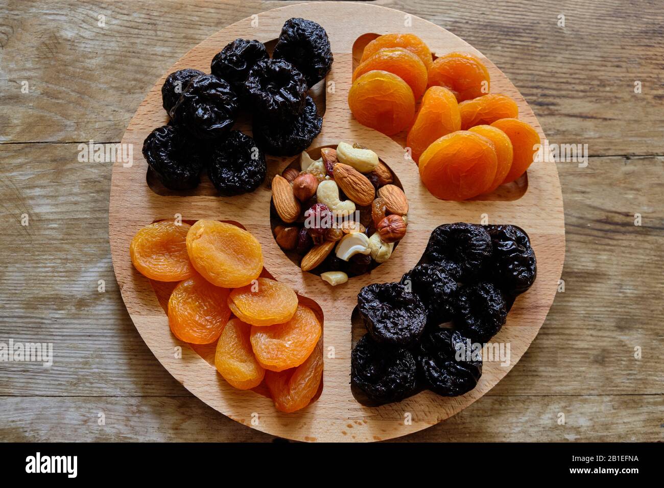 Abricots secs, pruneaux et mélanges de noix sur fond de bois résisté. Banque D'Images