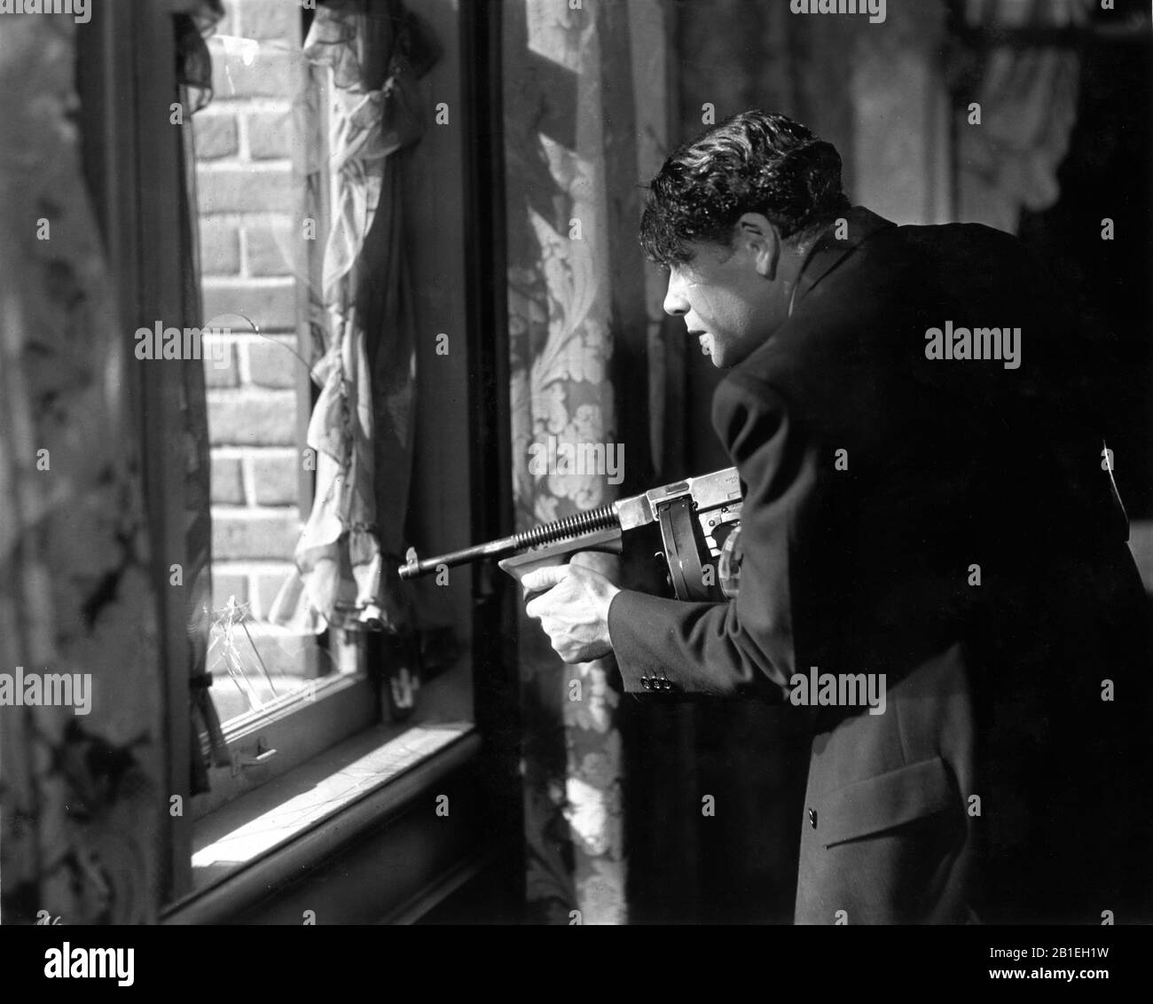 Paul Uni comme Tony Camonte tir Tommy Gun de fenêtre dans la bataille climatique dans SCARFACE 1932 directeurs HOWARD HAWKS et RICHARD ROSSON roman Armitage Trail histoire de l'écran Ben Hecht producteur Howard Hughes The Caddo Company / United Artists Banque D'Images
