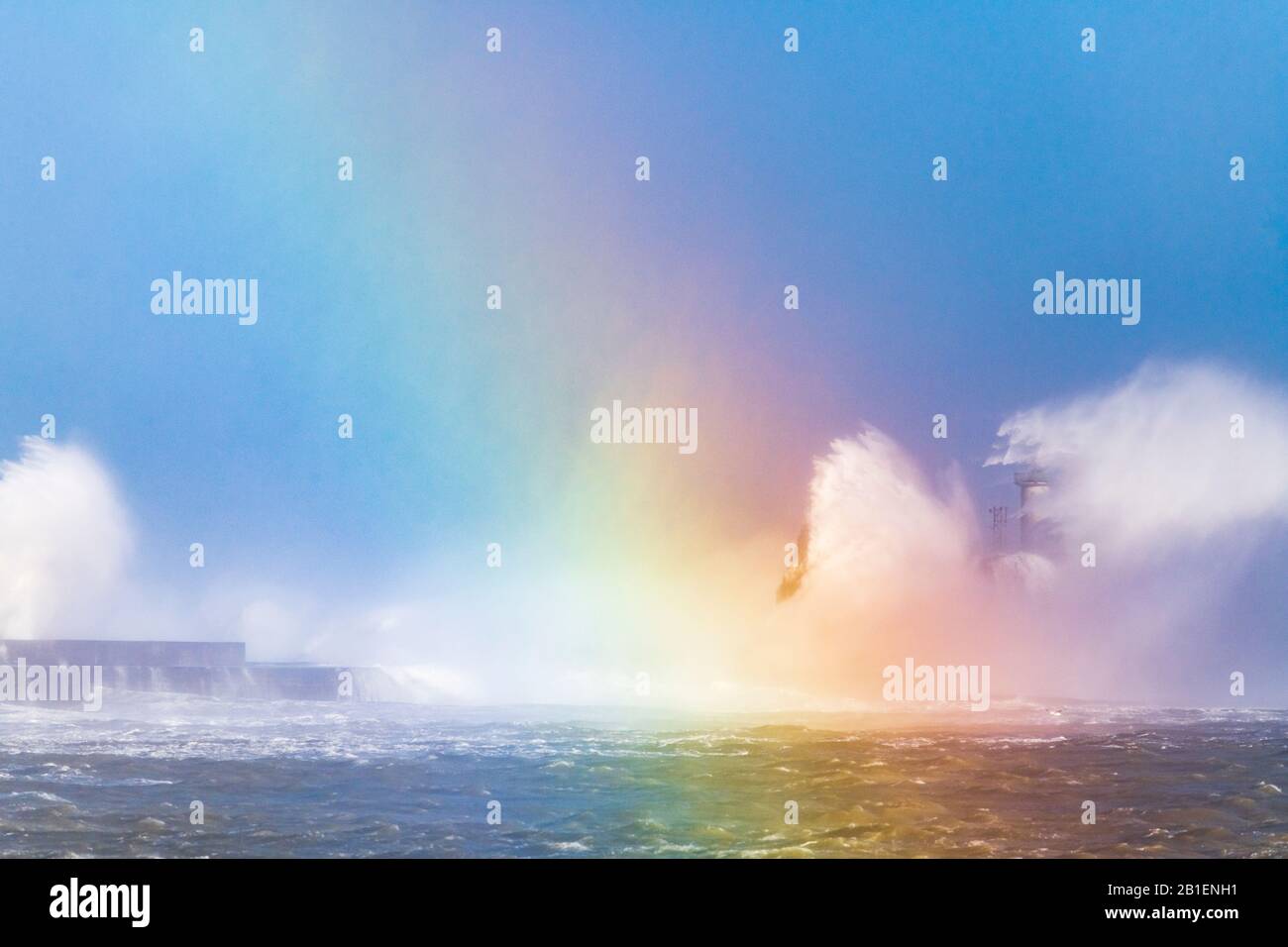 Vagues qui frappent le phare de la digue Carnot avec un arc-en-ciel créé par réflexion de lumière sur les vagues, pendant la tempête Ciara, Boulogne sur mer, Banque D'Images
