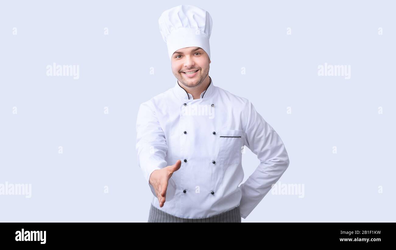 Chef Étirant La Main Pour Le Service De Salutation À Main Debout, Fond Blanc, Panorama Banque D'Images