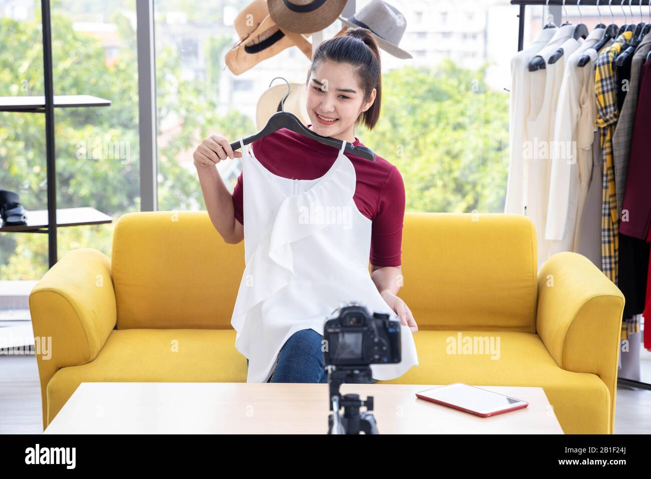 Heureux Asian Internet influenceur examiner ou vendre des robes blanches par streaming en ligne. Banque D'Images
