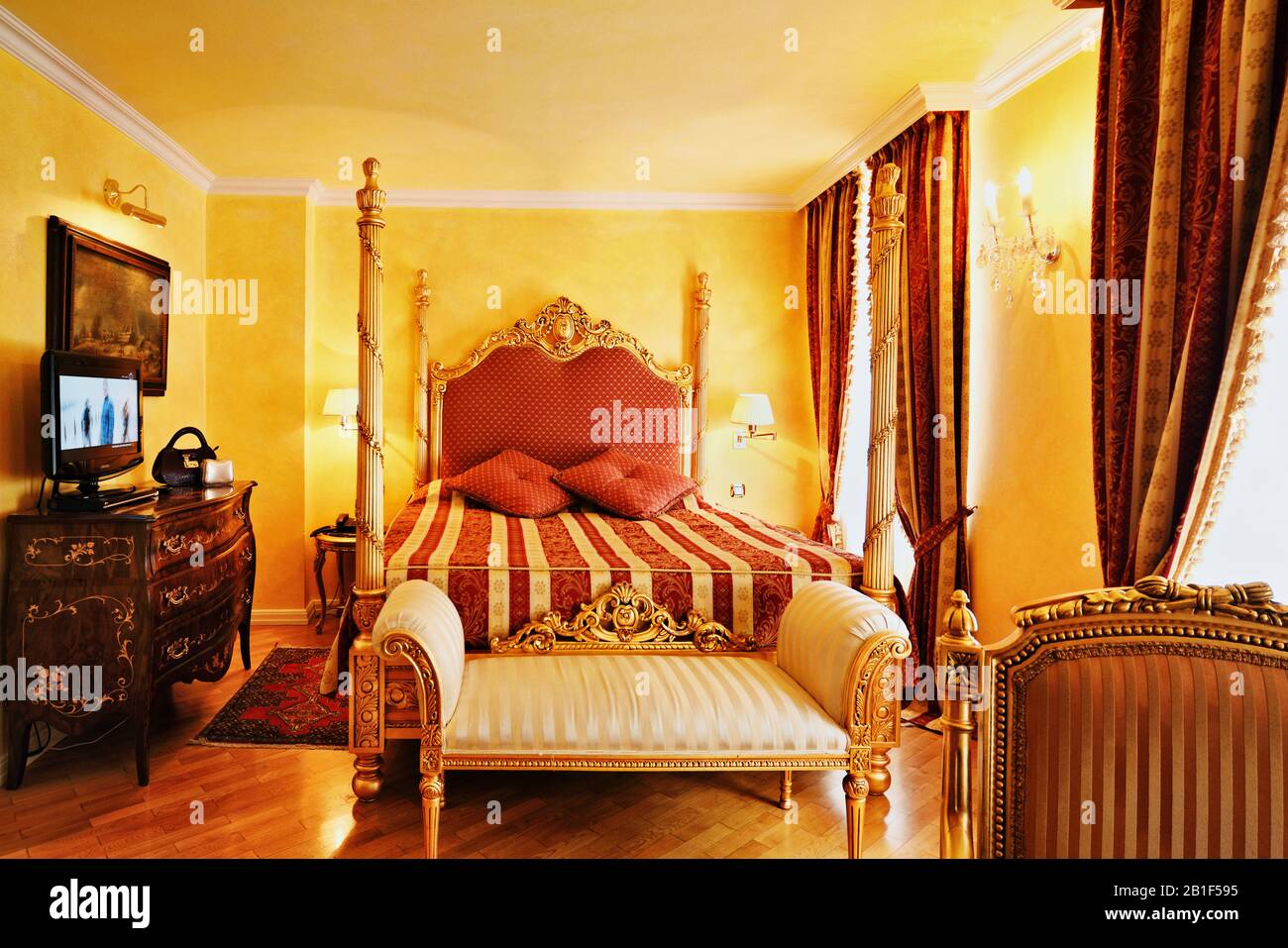 Le luxe baroque des meubles dorés et des tissus de brocart rouges et dorés décorent un intérieur luxuriant et une chambre d'hôtel à l'allure royale à Prague Banque D'Images