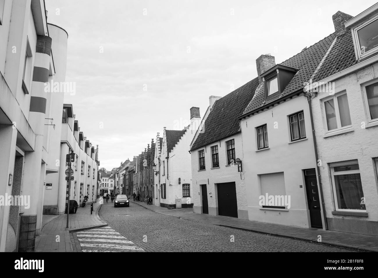 Même en dehors de son centre médiéval bondé, Bruges offre de charmantes rues, ici avec de jolies maisons blanches. Une voiture vous conduit dans la rue pavée. Banque D'Images Même en dehors de son centre médiéval bondé, Bruges offre de charmantes rues, ici avec de jolies maisons blanches. Une voiture vous conduit dans la rue pavée. Banque D'Images
