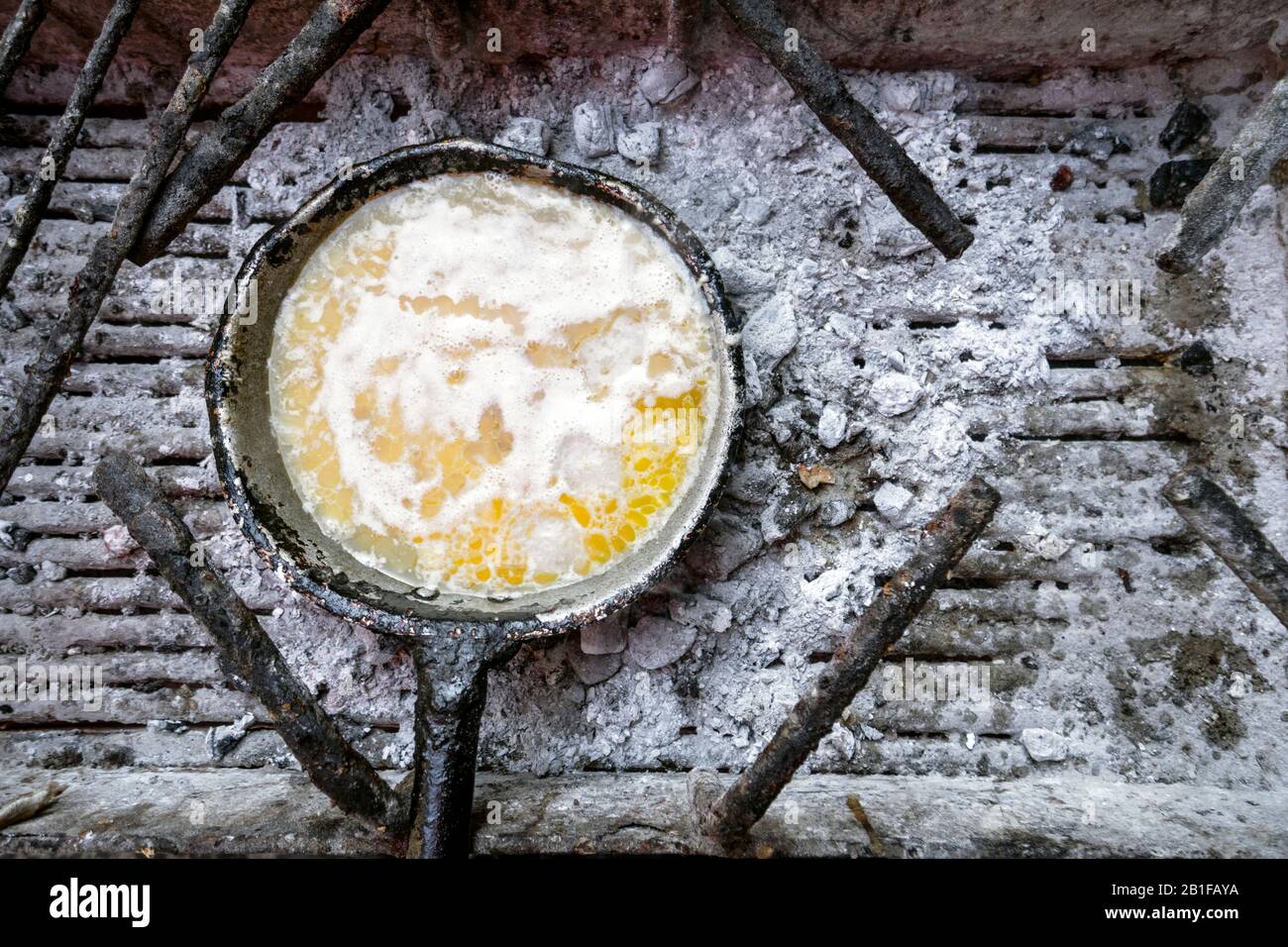 Clarifier le beurre sur la poêle à frire sur le charbon de bois au Mozambique, en Afrique Banque D'Images