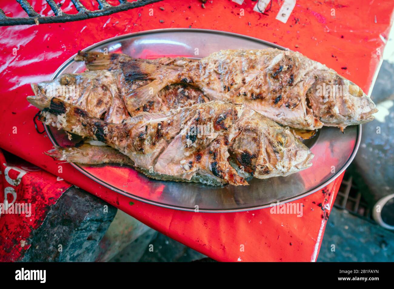 Deux poissons barbecue servis sur un plateau argent, au Mozambique Banque D'Images