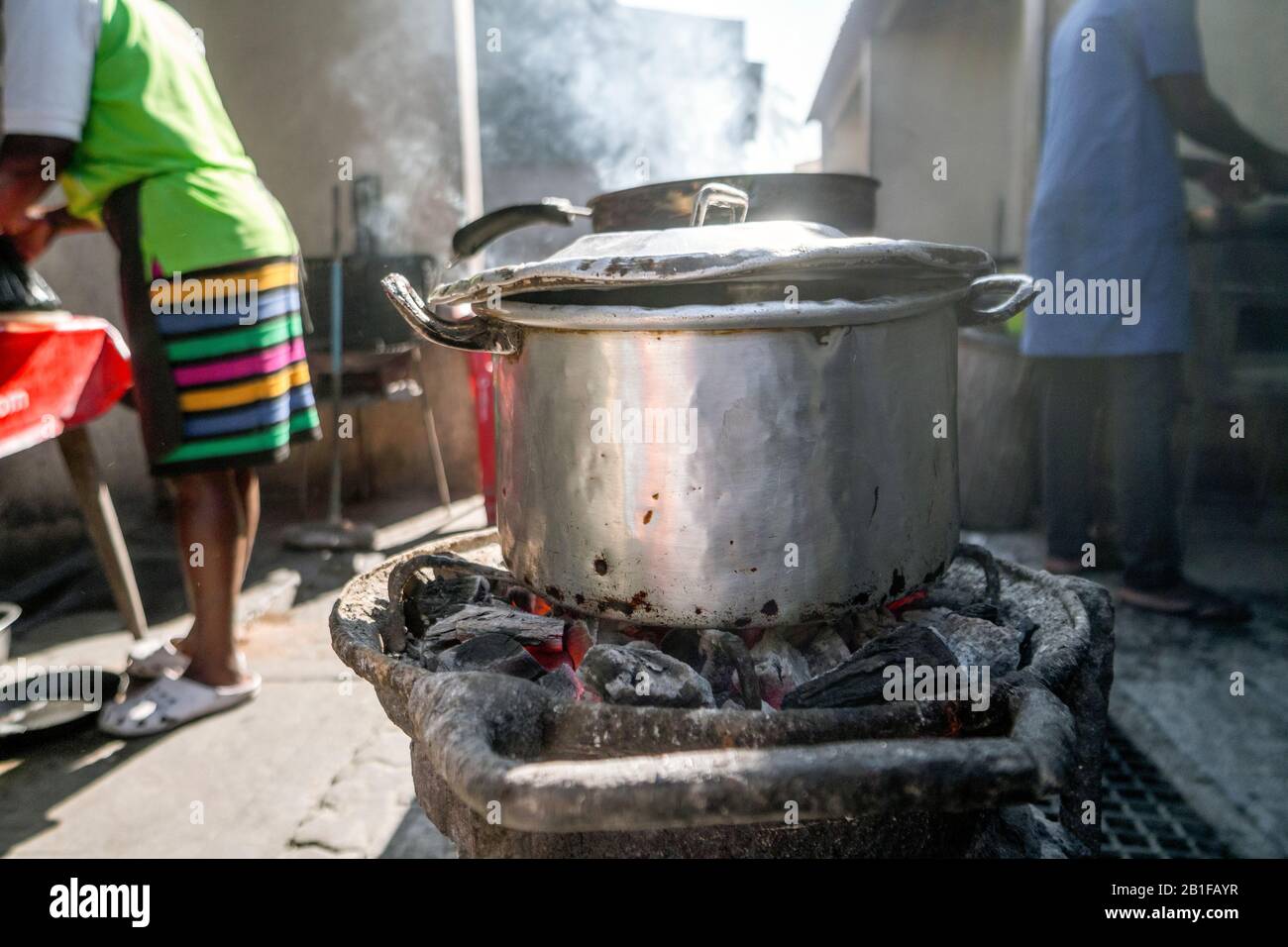 Marmite en argent vapeur au charbon de bois contre le soleil, cuisine extérieure au Mozambique Banque D'Images