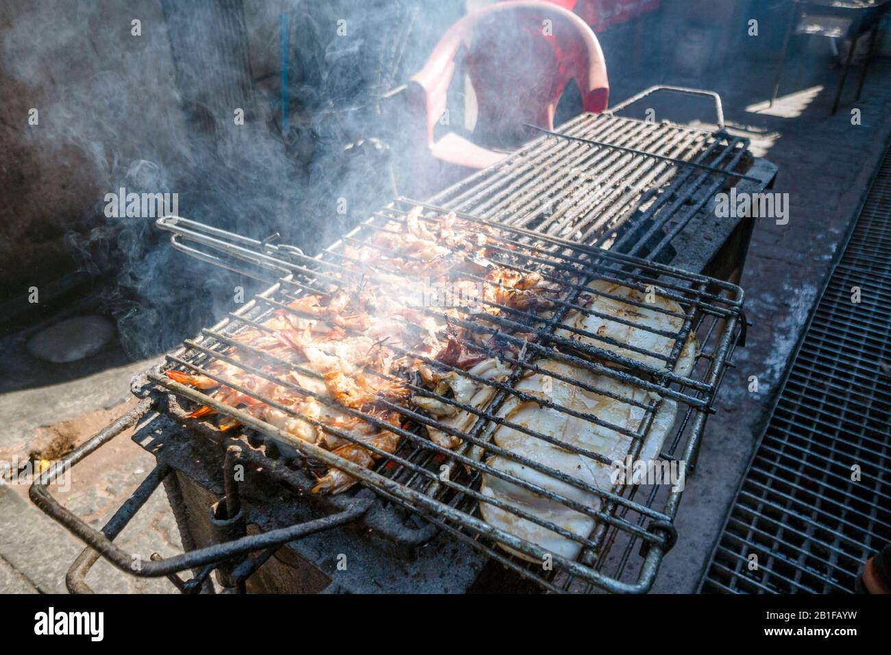 Homards grillés et poissons encore sur le feu de barbecue dans la cuisine africaine Banque D'Images