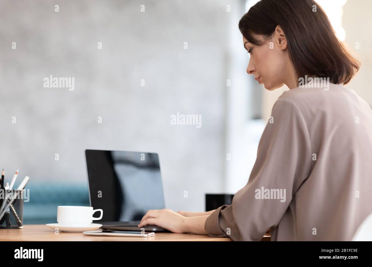 Une jeune femme travaillant avec un ordinateur portable Banque D'Images