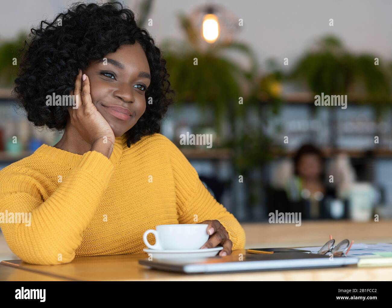 Une femme noire pensive qui a fait une pause café au café Banque D'Images