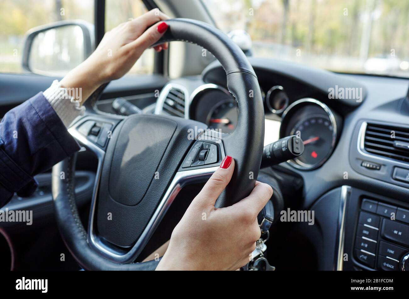 Les mains sur le volant d'une voiture pendant la conduite Banque D'Images