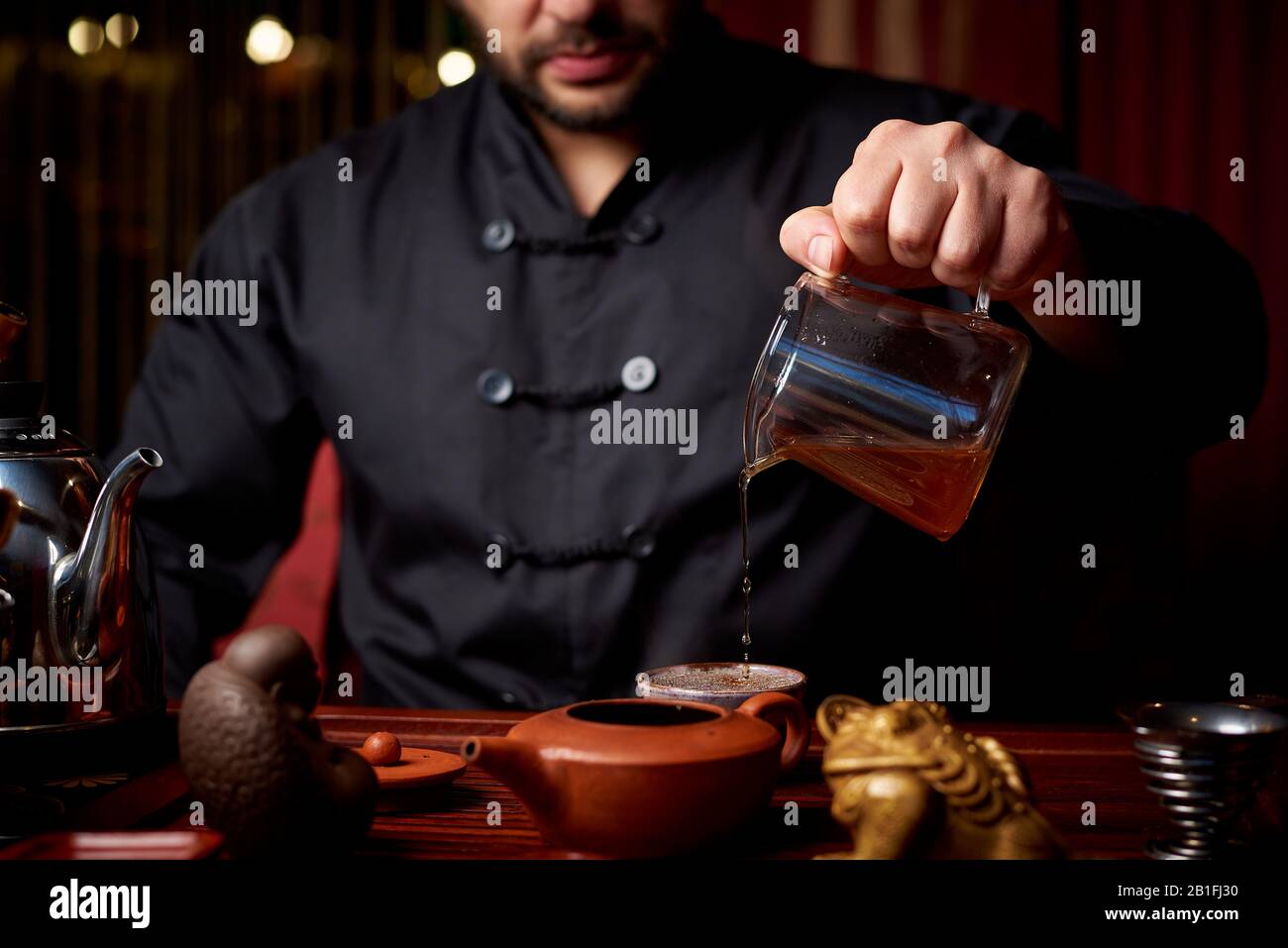 Cérémonie du thé. Un jeune homme verse du thé à partir d'une théière. Banque D'Images