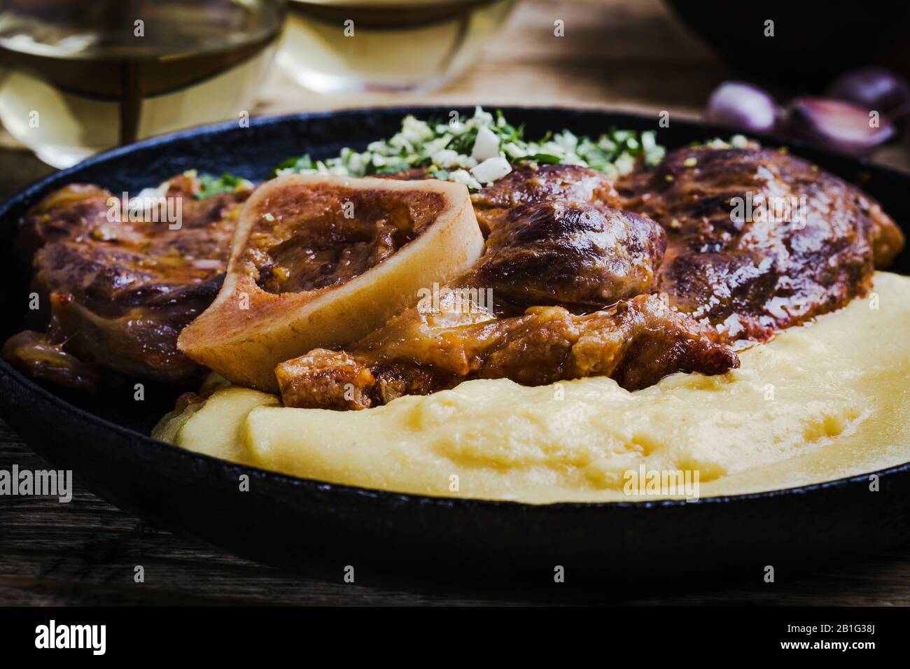 Osso buco avec gremolata, condiment de hacher le cilantro, l'ail, et le zeste de citron, servi avec polenta. Cuisine italienne traditionnelle Banque D'Images