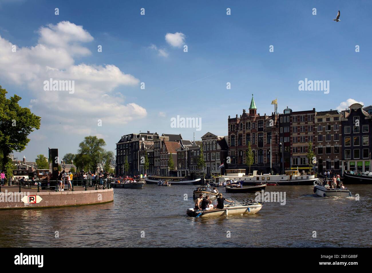 Avis de personnes équitation ouvrir bateaux dans la rivière Amstel faisant canal cruise tours. Traditionnel et historique, les bâtiments sont typiques dans l'arrière-plan. C'est Banque D'Images