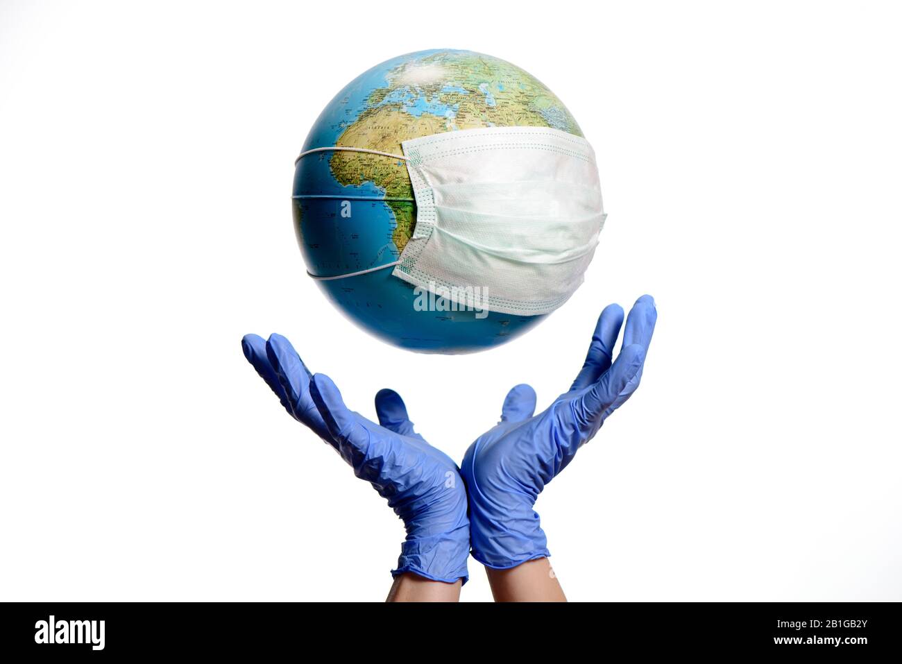 Le globe terrestre avec un masque de protection et des mains, isolé sur un fond blanc. Épidémie Humaine Danger. Globe terrestre avec texte hongrois. Banque D'Images