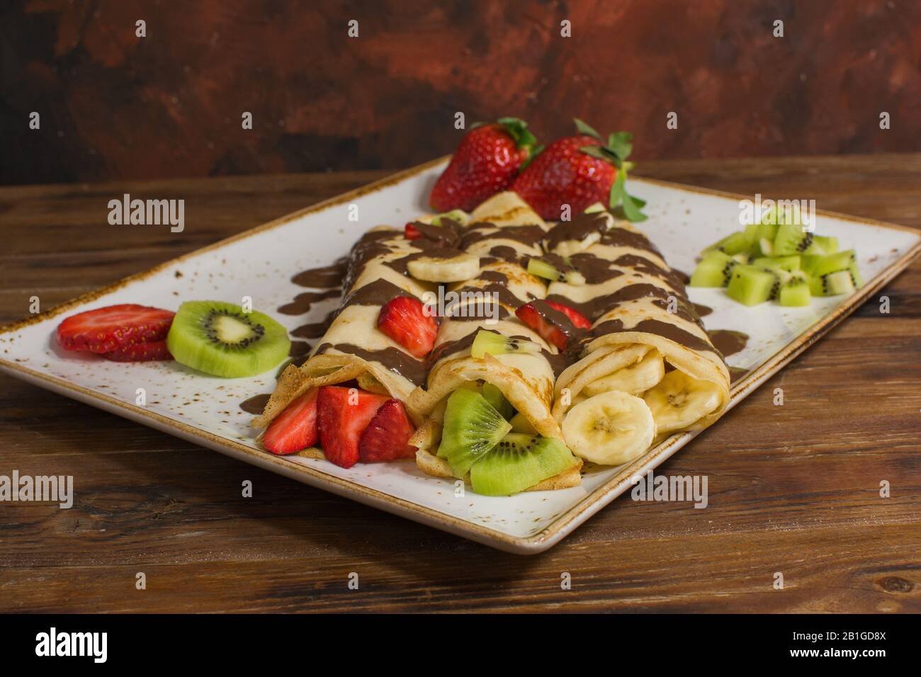 Crêpes saines avec fruits, banane, kiwi et fraise. Petit déjeuner français sain Banque D'Images