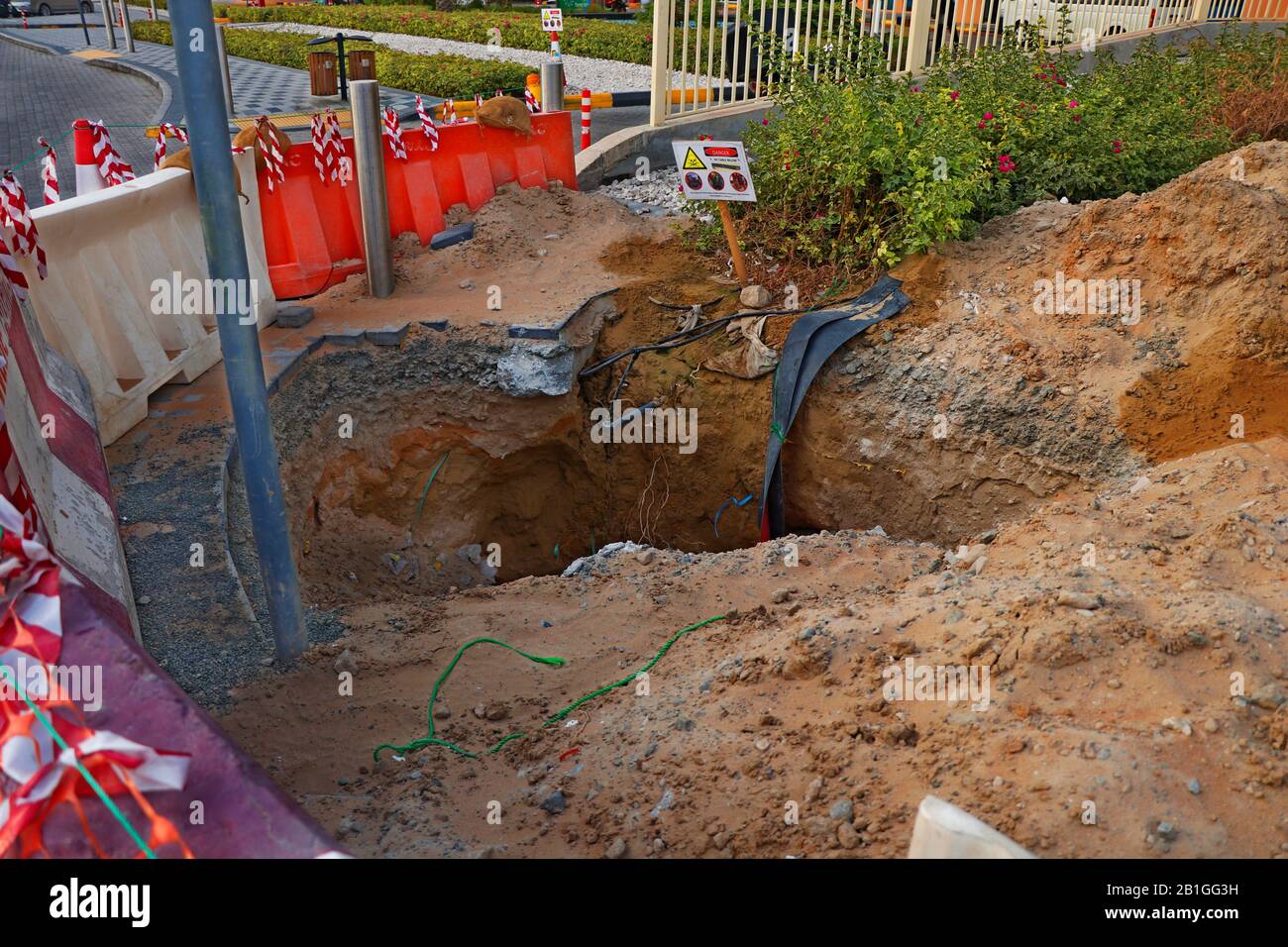 excavation profonde avec des poteaux de mise en garde côté d'une route, partie des travaux de construction Banque D'Images