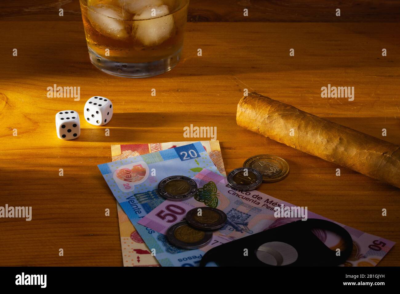 Jeu - tabac Cigar, dés blancs, whisky écossais et billets de banque au mexique sur la table en bois Banque D'Images