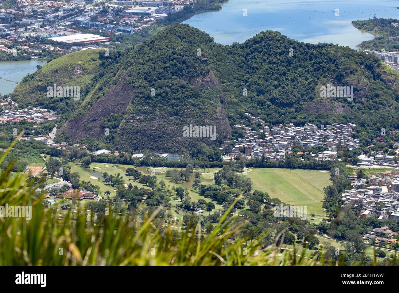 Club de golf dans le quartier de Barra da Tijuca à Rio de Janeiro avec lac de ville derrière vu du rocher de Pedra Bonita dans la forêt de Tijuca Banque D'Images