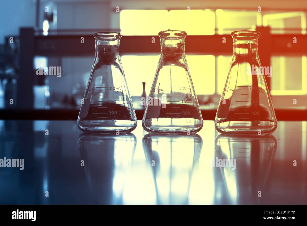 flacon à trois verres sur fond bleu du laboratoire de science de la chimie de la recherche Banque D'Images
