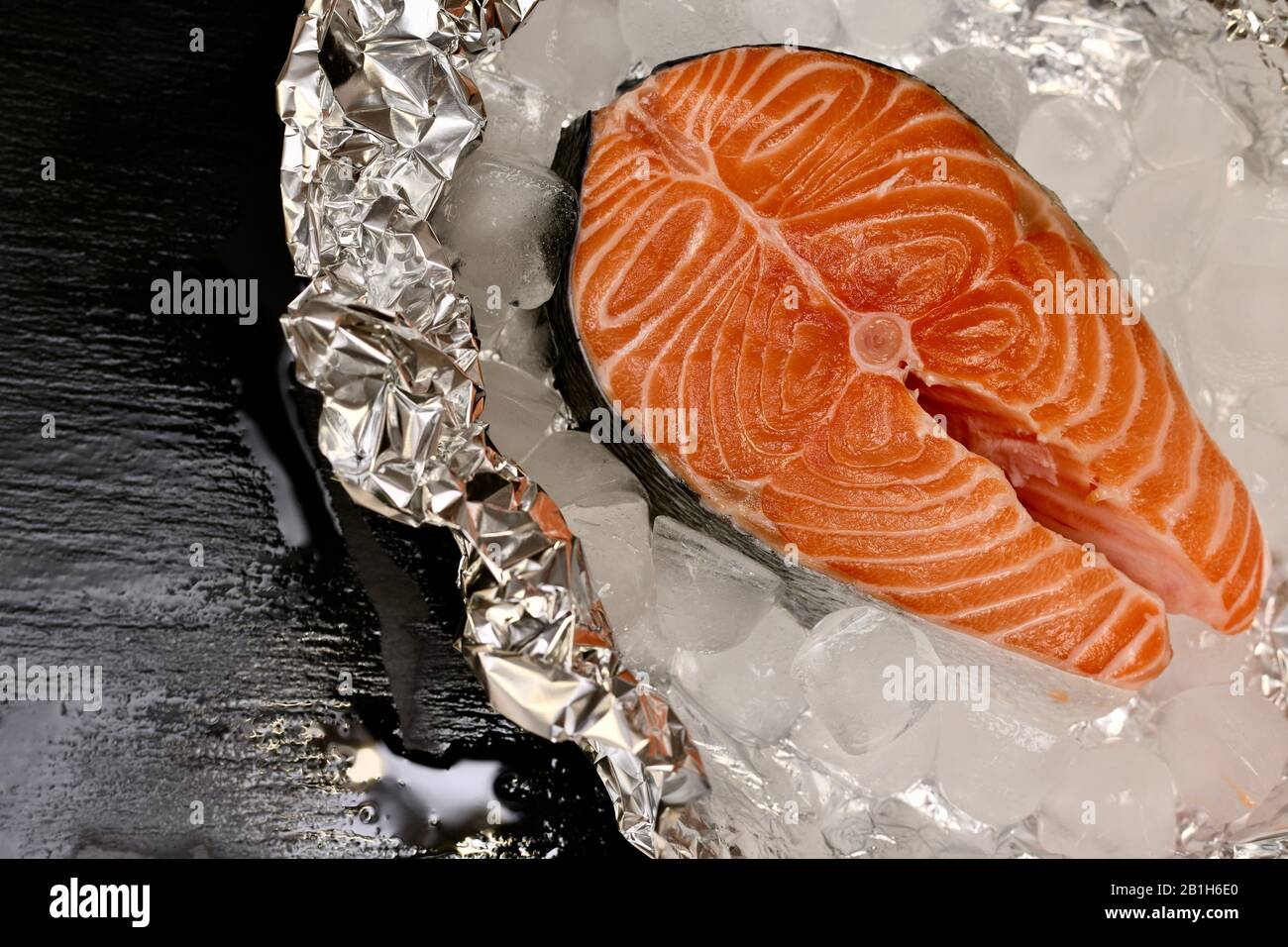 Placer horizontalement le steak de saumon sur du papier aluminium avec de la glace. Banque D'Images