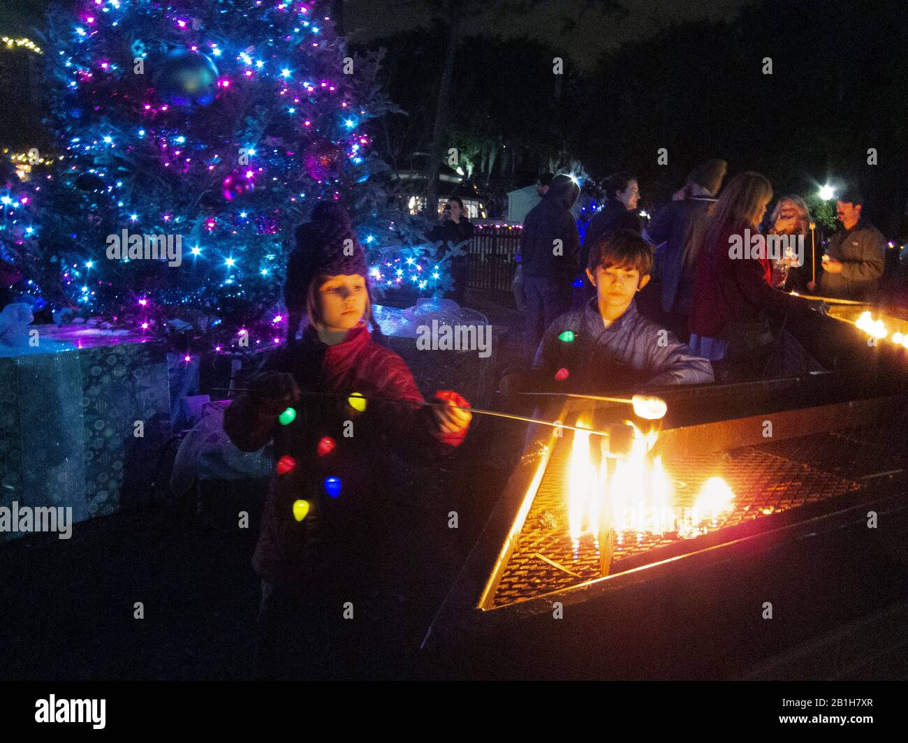Deux enfants qui toasting des guimauves au parc de la ville pendant la saison de Noël. La Nouvelle-Orléans, LA. Banque D'Images