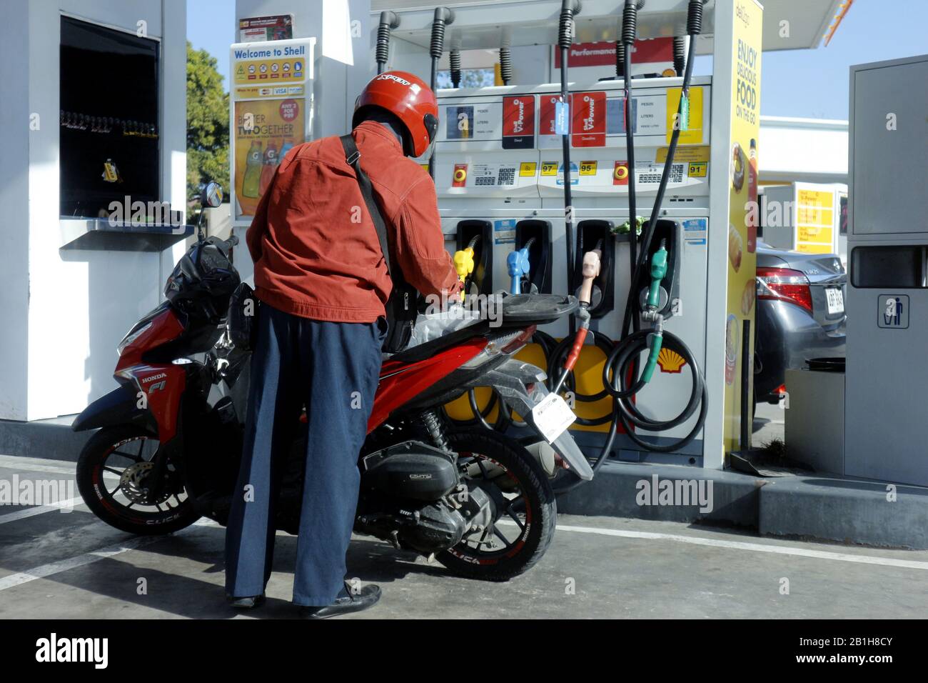 Cainta, Rizal, Philippines - 16 février 2020: Le motocycliste s'arrête pour se réapprovisionner à une station de remplissage de gaz. Banque D'Images