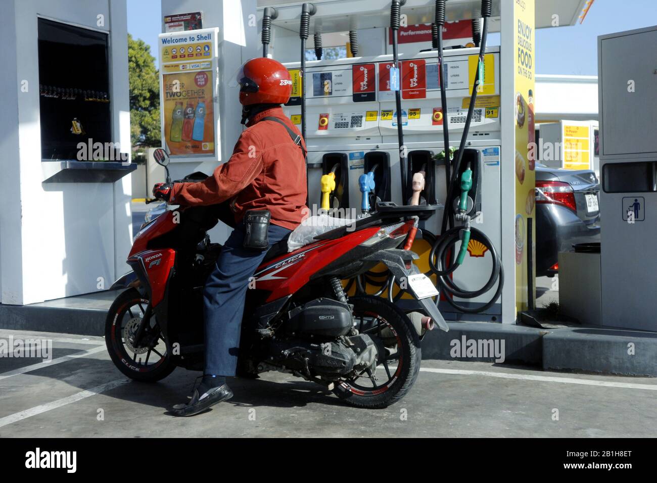 Cainta, Rizal, Philippines - 16 février 2020: Le motocycliste s'arrête pour se réapprovisionner à une station de remplissage de gaz. Banque D'Images