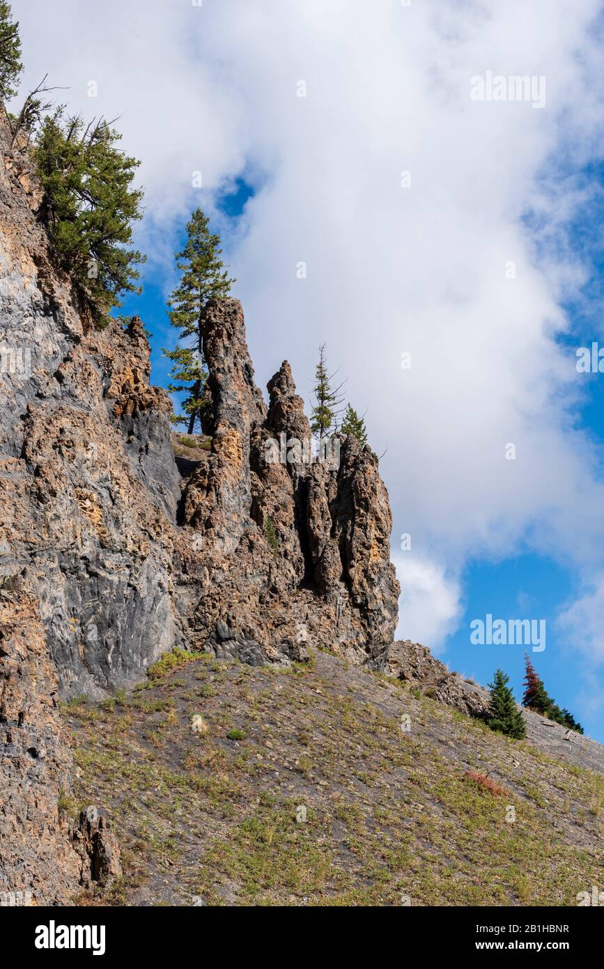 Sommets rocheux, arbres verts et nuages blancs avec ciel bleu. Aucun masque requis par nature. Banque D'Images