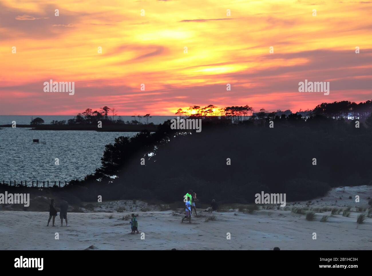 Les gens qui marchent sur le sable alors que le soleil se couche sur le détroit d'Albemarle au parc national de JockeyÕs Ridge, le plus haut Banque D'Images