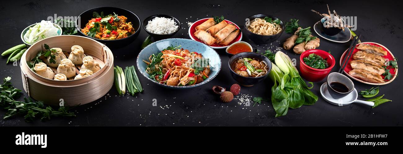 Assortiment de plats chinois sur fond sombre. Concept alimentaire asiatique. Panorama, bannière Banque D'Images
