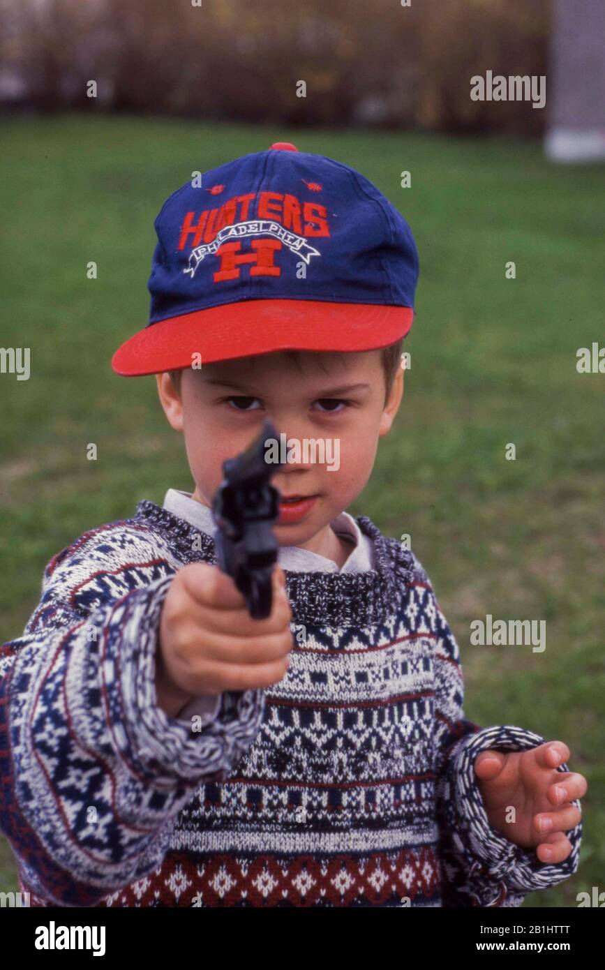 Petit garçon vise avec un pistolet jouet. Banque D'Images
