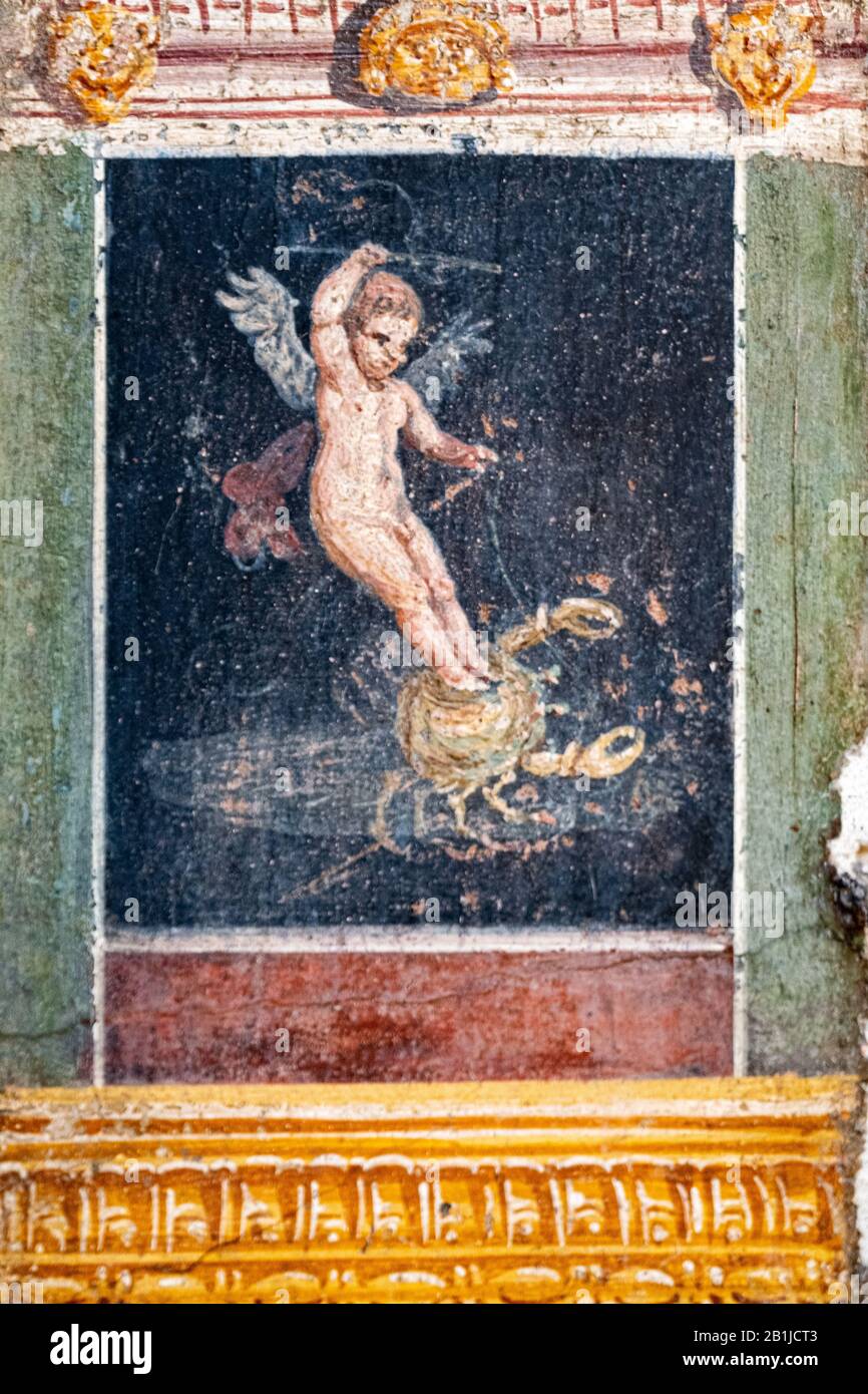 L'Amorino ailé mène un crabe, une figure de la Rome antique à Pompéi. Banque D'Images