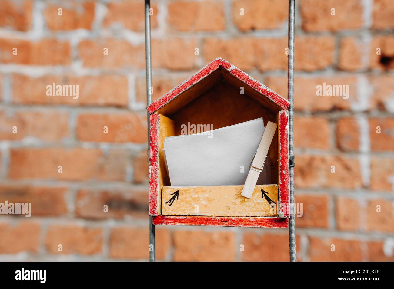 Une maison en bois avec des papiers pour des notes à l'intérieur, attaché avec un clothesspin contre le fond d'un mur de briques dans la rue. Objet art La Capacité t Banque D'Images
