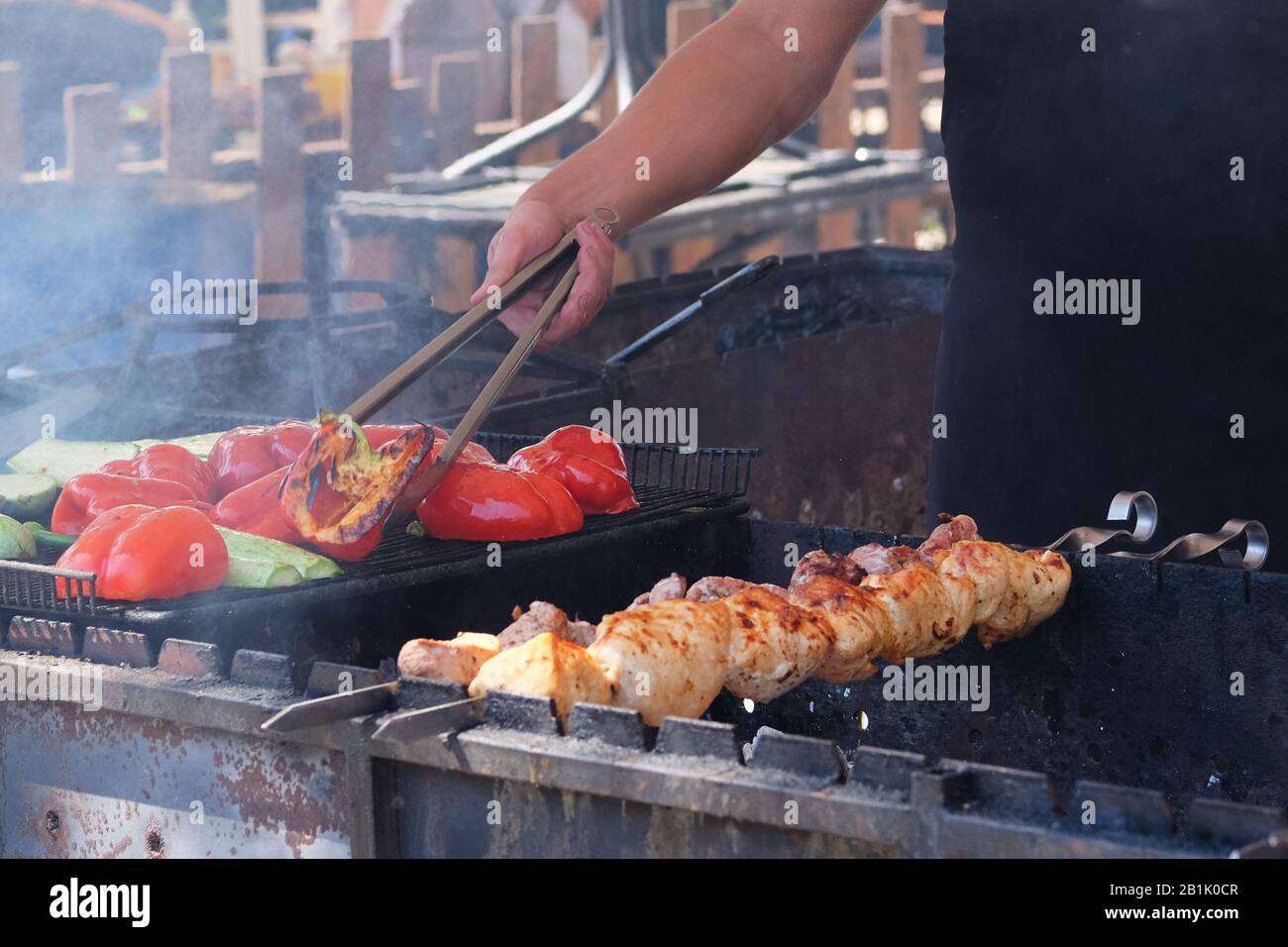 Faites frire la viande et les légumes sur le gril. Faire cuire dans des poivrons rouges rôtis à tablier noir et des courgettes. Barbecue en plein air. Banque D'Images