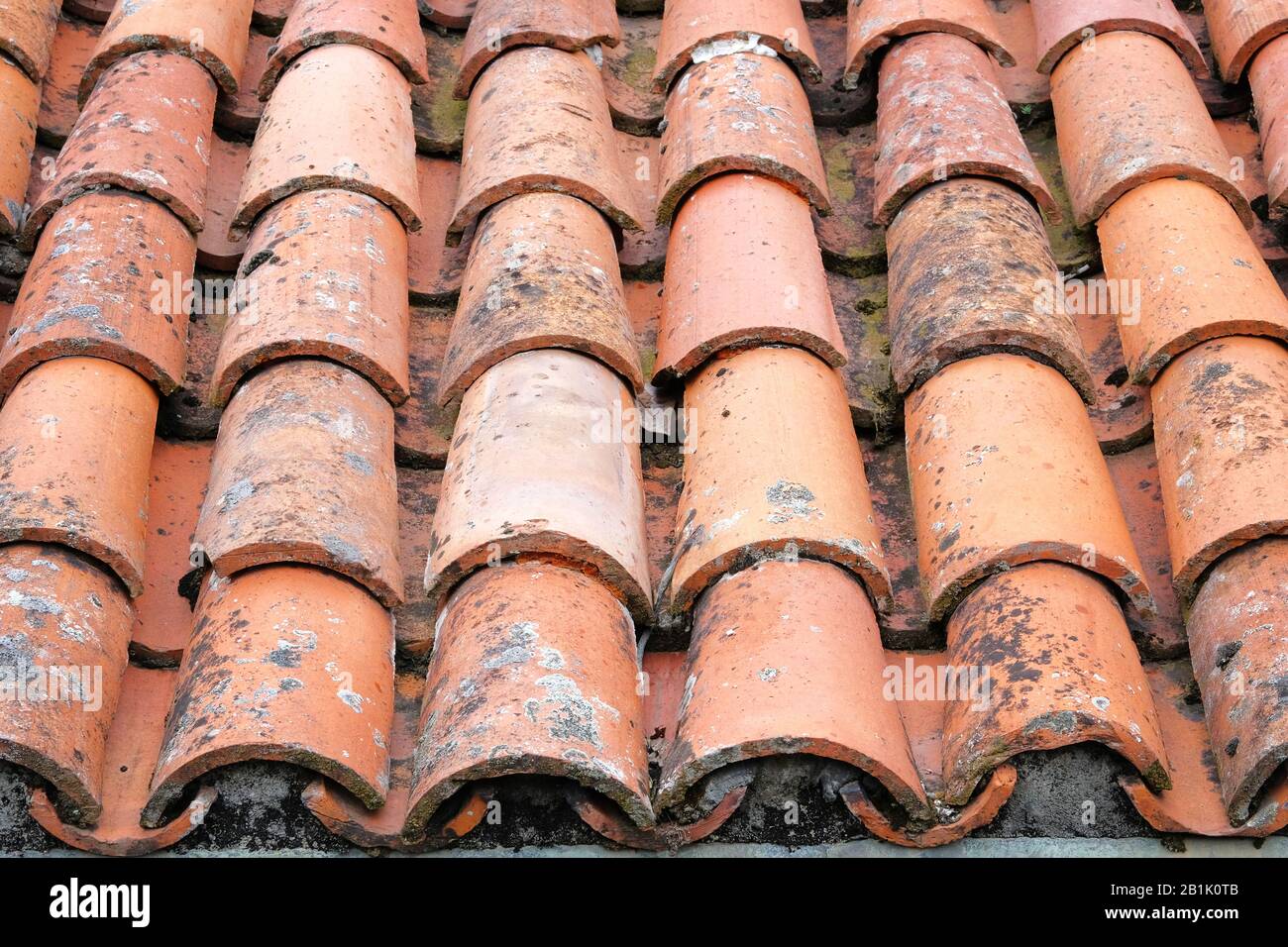 Vieilles tuiles de toit en terre cuite sur le toit d'une ancienne maison. Motif de tuiles arrière-plan de toit. Banque D'Images