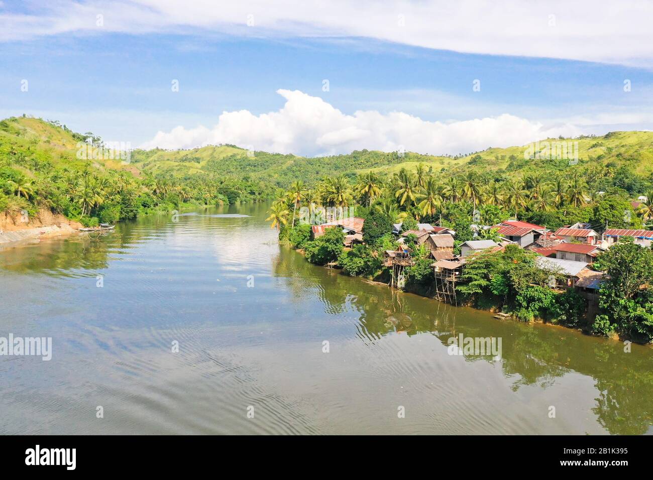 Rivière et collines vertes. Beau paysage naturel de la rivière en Asie du sud-est. Campagne sur une grande île tropicale. Petit village sur les collines vertes près de la rivière. La nature des Philippines. Banque D'Images