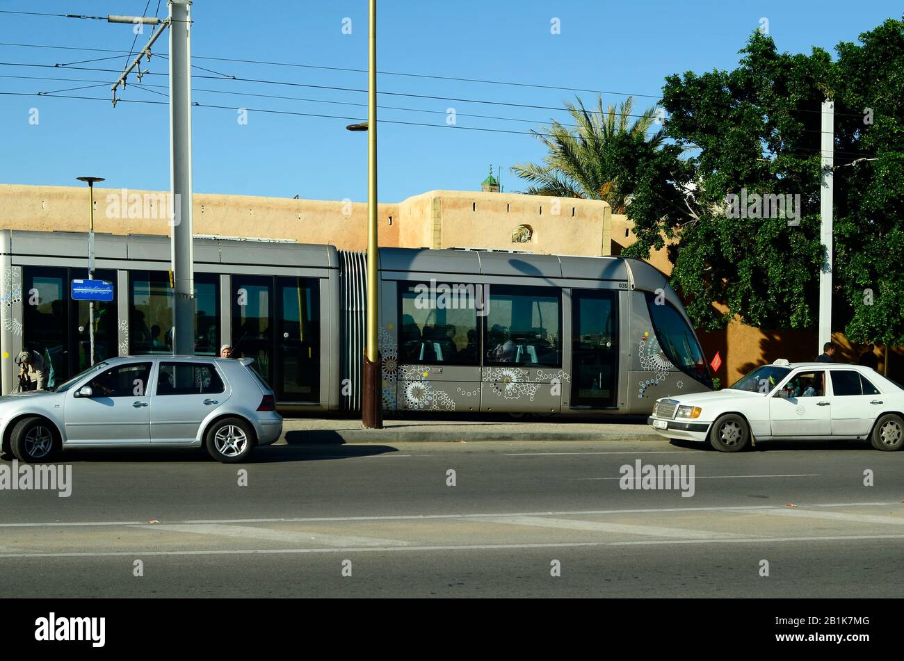 Meknes, Maroc - 18 novembre 2014 : personnes non identifiées et tramway moderne, mode de transport public, mur médiéval de la ville derrière Banque D'Images
