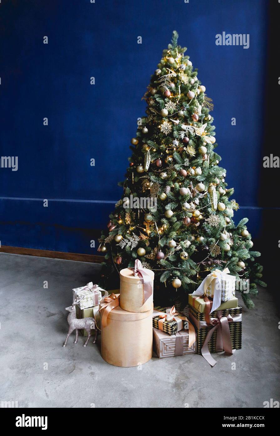 Arbre de conifères vert décoré de boules dorées le jour de Noël à la maison Banque D'Images