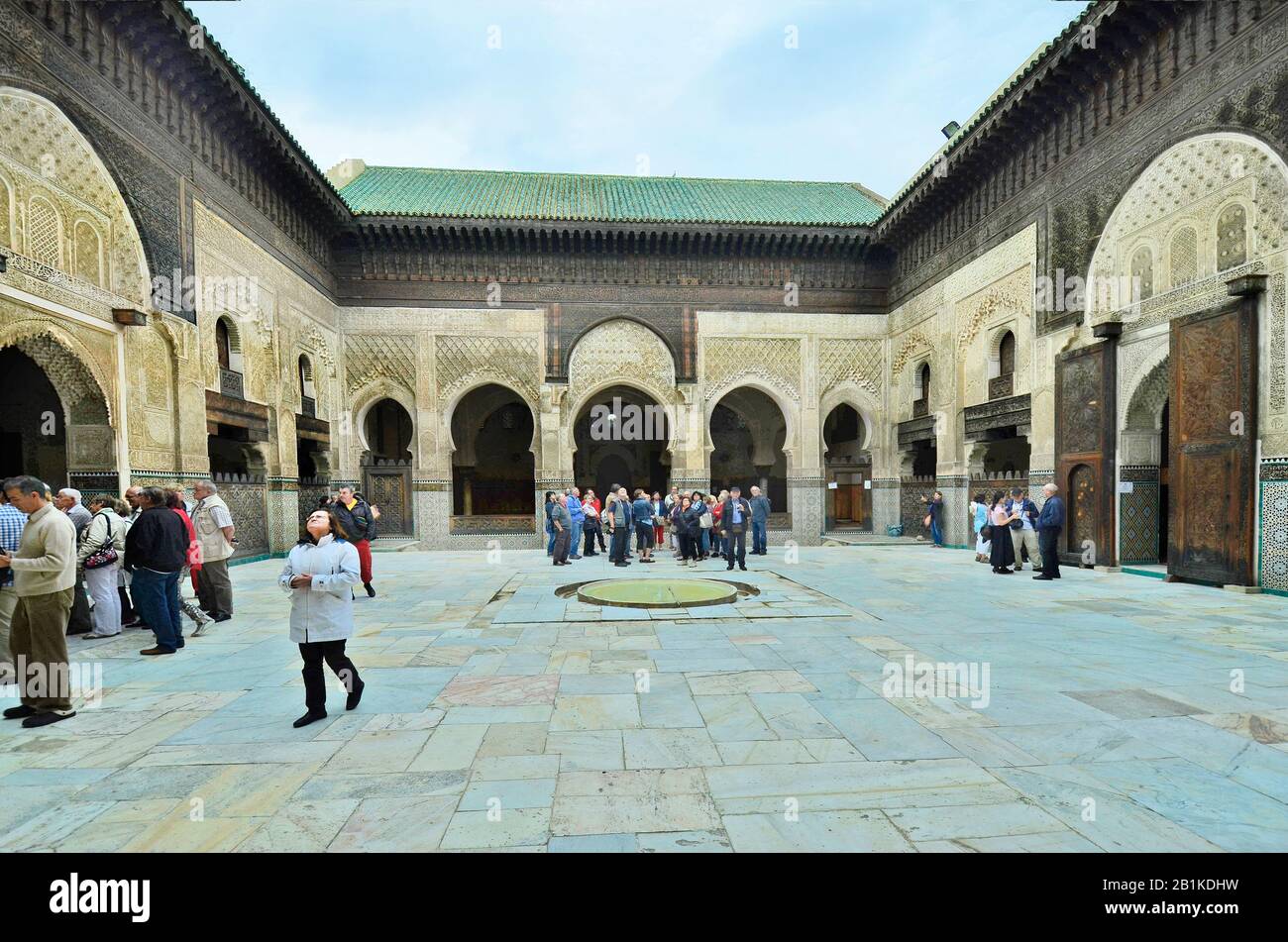 Fez, Maroc - 20 novembre 2014 : groupe non identifié de touristes dans la cour intérieure de Medersa Bou Inania avec des ornements artistiques - un scho islamique Banque D'Images