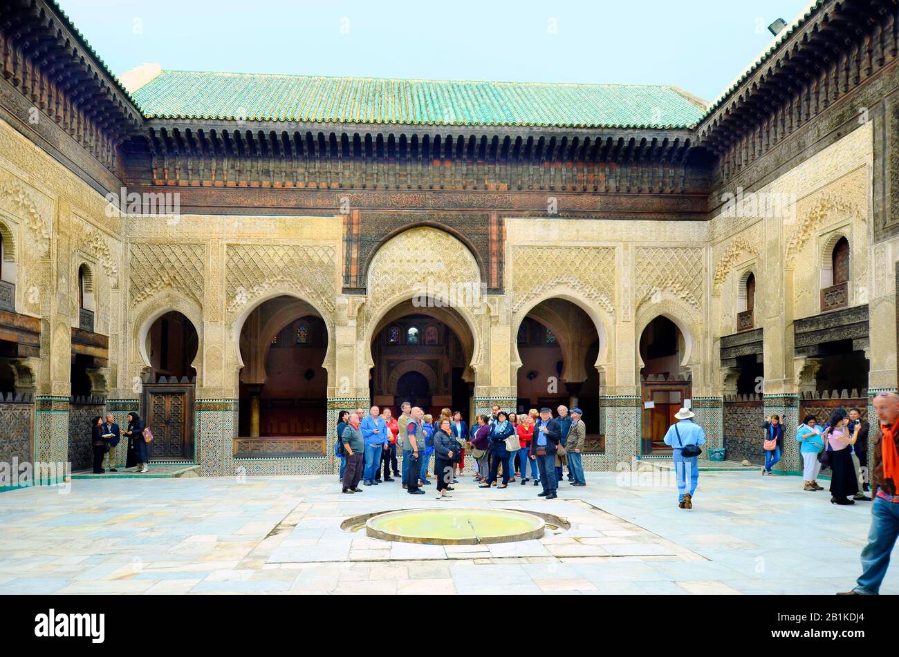 Fez, Maroc - 20 novembre 2014 : groupe non identifié de touristes dans la cour intérieure de Medersa Bou Inania avec des ornements artistiques - un scho islamique Banque D'Images