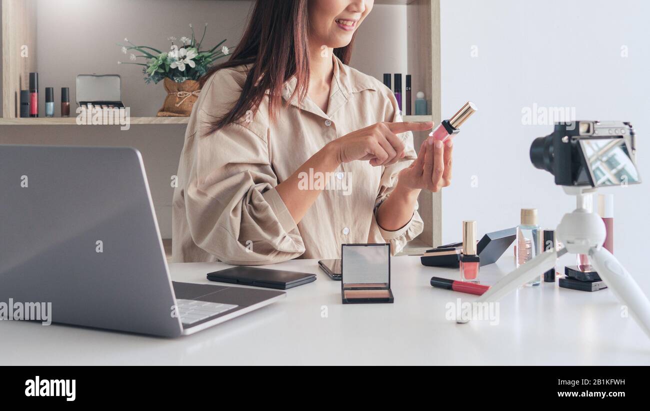 Belle femme asiatique de l'esthétique professionnelle vlog ou blogger présente les produits cosmétiques et l'application de maquillage en caméra frontale pour l'enregistrement vidéo Banque D'Images