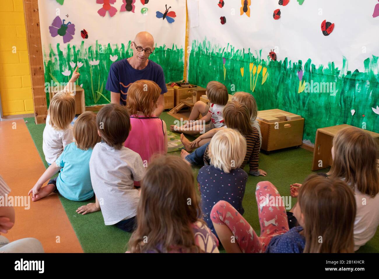 Éducateur, homme, assis à l'étage avec un groupe d'enfants à la maternelle, Cologne, Rhénanie-du-Nord-Westphalie, Allemagne Banque D'Images