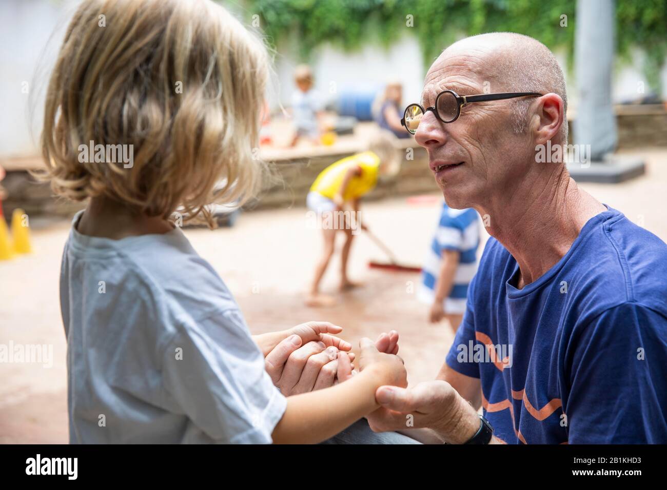 L'éducateur parle à l'enfant à la maternelle, à Cologne, en Rhénanie-du-Nord-Westphalie, en Allemagne Banque D'Images
