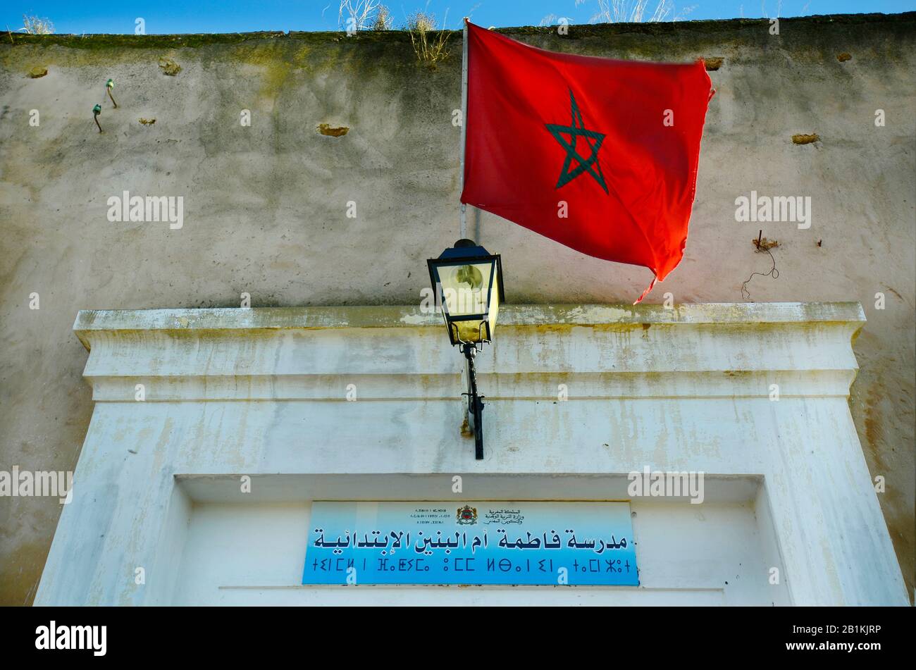 Maroc, Meknes, entrée à l'immeuble de bureaux avec drapeau et planche marocains en arabe et en écriture berbère Banque D'Images