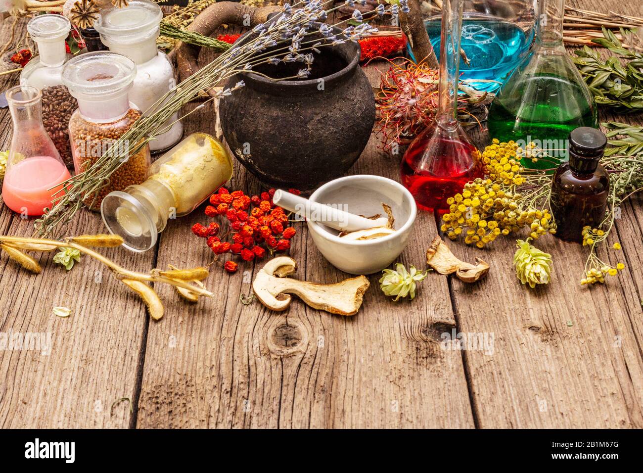 Laboratoire des sorcières. Équipement alchimique, traitement apothécaire. Mortier et pilon, bouteilles, poudres, herbes sèches. Concept Halloween, vieux panneaux en bois b Banque D'Images